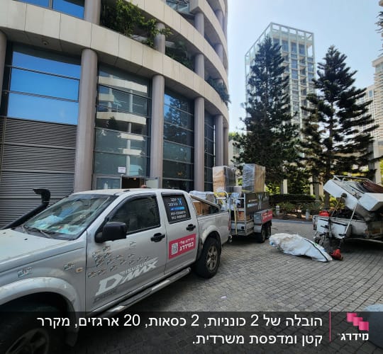 רכב הובלה עם ציוד ארוז ליד בניין גבוה